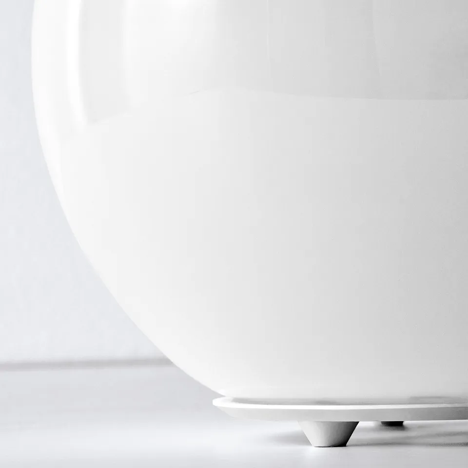 Close-up of modern globe lamps base. Smooth, white glass meets sleek polypropylene base, highlighting quality craftsmanship.