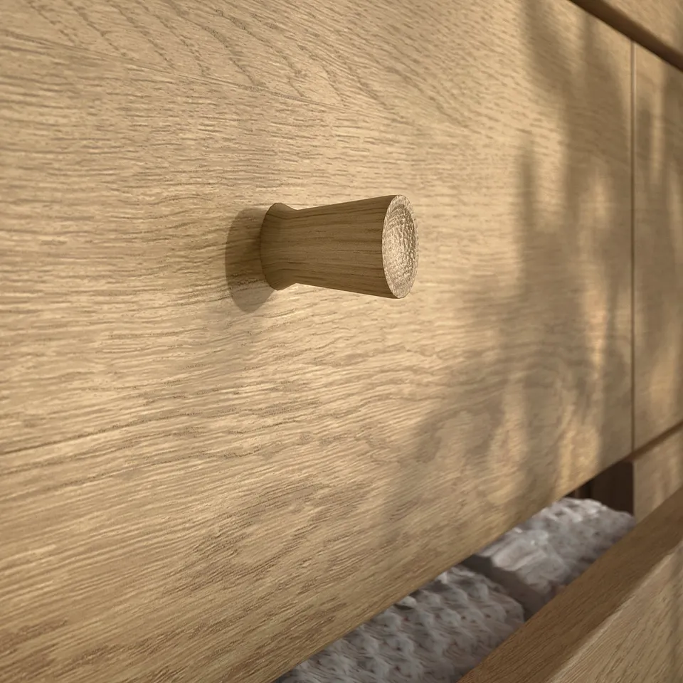 Wooden drawer with round, textured handle. Grain and finish visible. Soft-close mechanism implied.