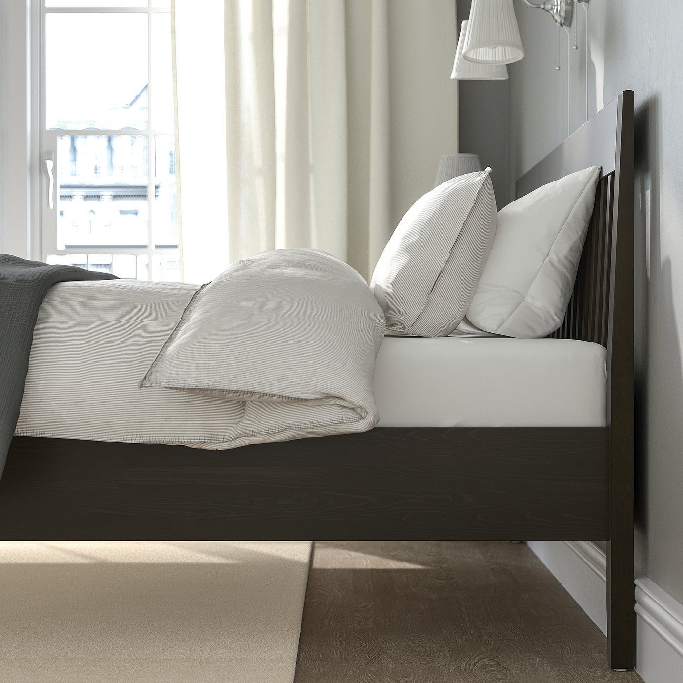 Tidy bedroom with black bedframe featuring clean sheets, white pillows, and curtained window, showcasing organised sleep area.