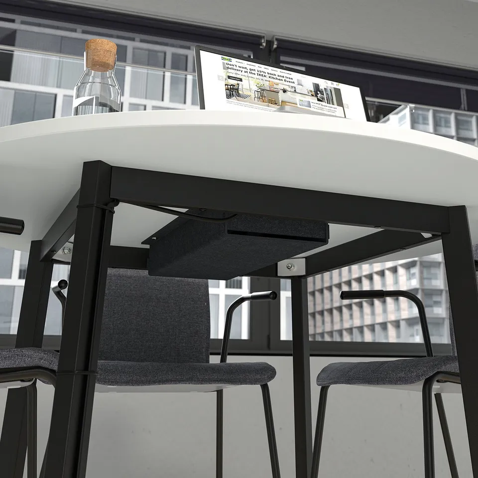 Round conference table with chairs, city view. Includes cable management tray, perfect for small meetings.