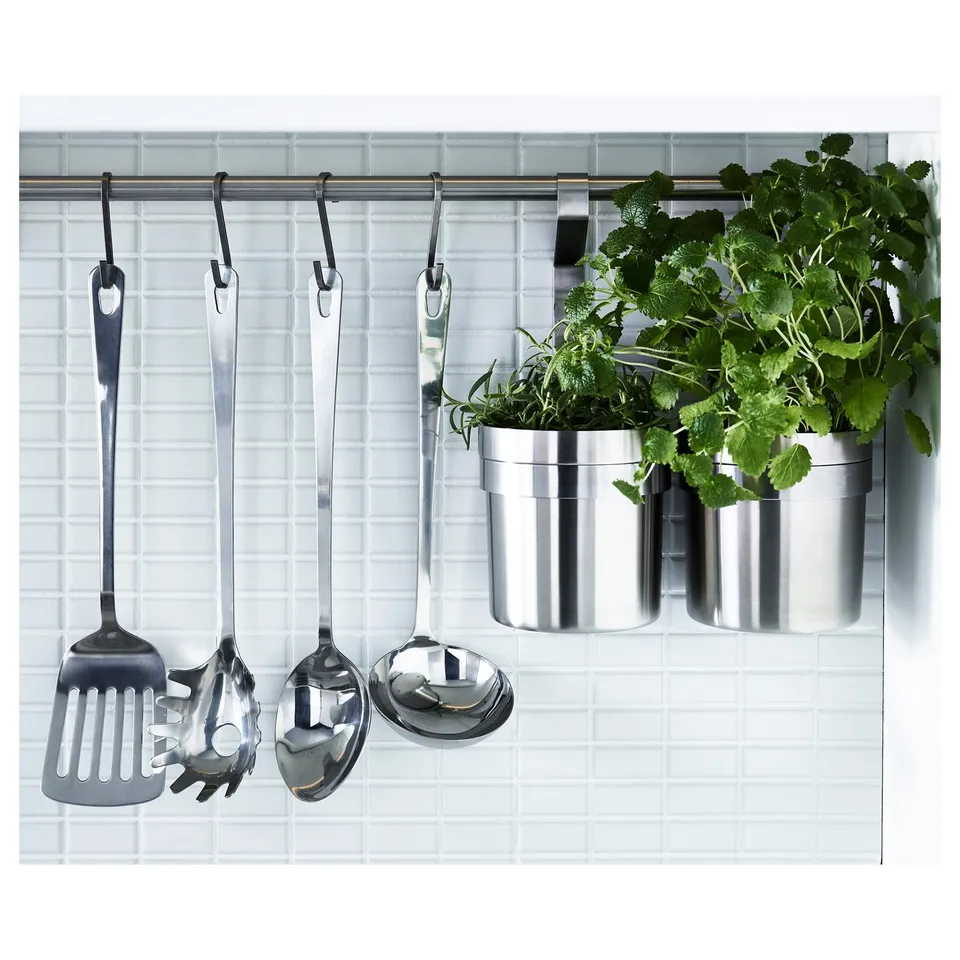 Metal hanging racks with kitchen utensils and plants. Includes spatula, spoon, ladle, and spaghetti server; perfect for organised kitchen storage.