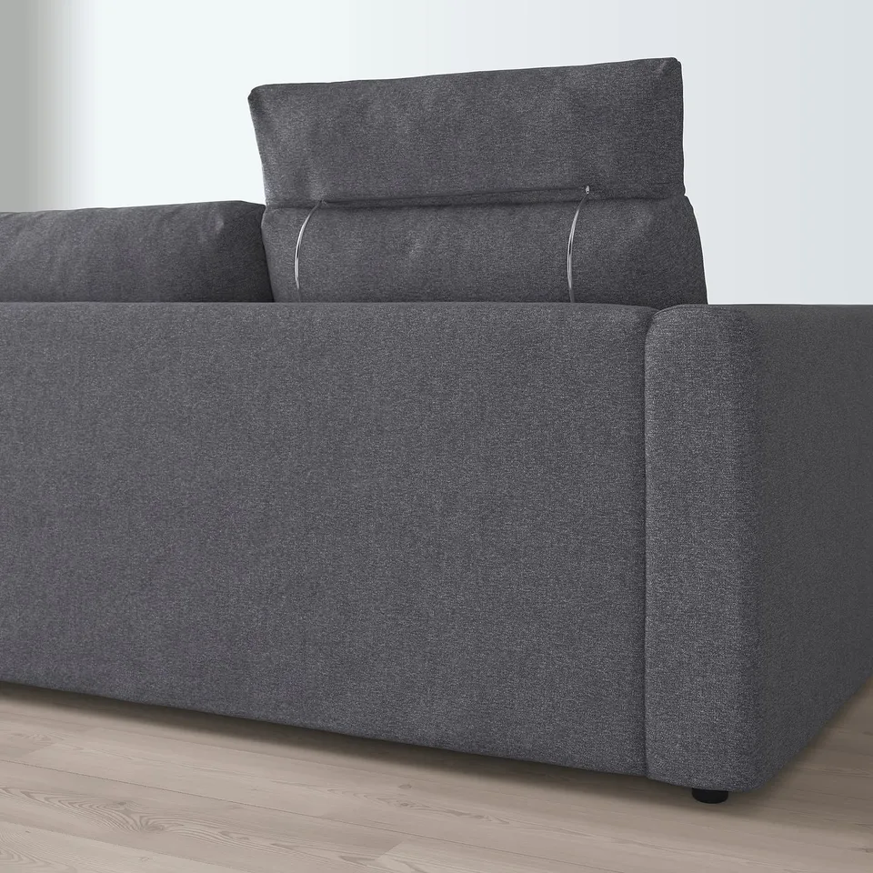 Dark grey l-shaped sectional sofa with adjustable headrests, one pillow shown.