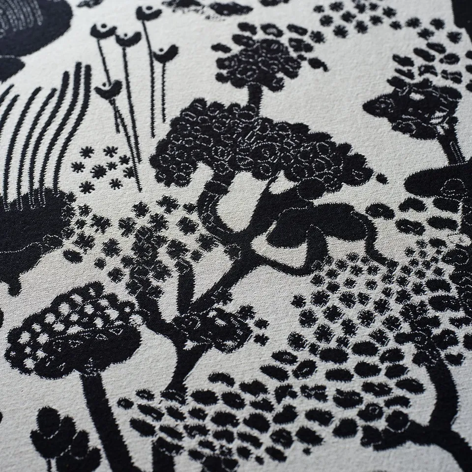 Black and white floral fabric detail. Intricate pattern with flowers and stems on textured cotton.