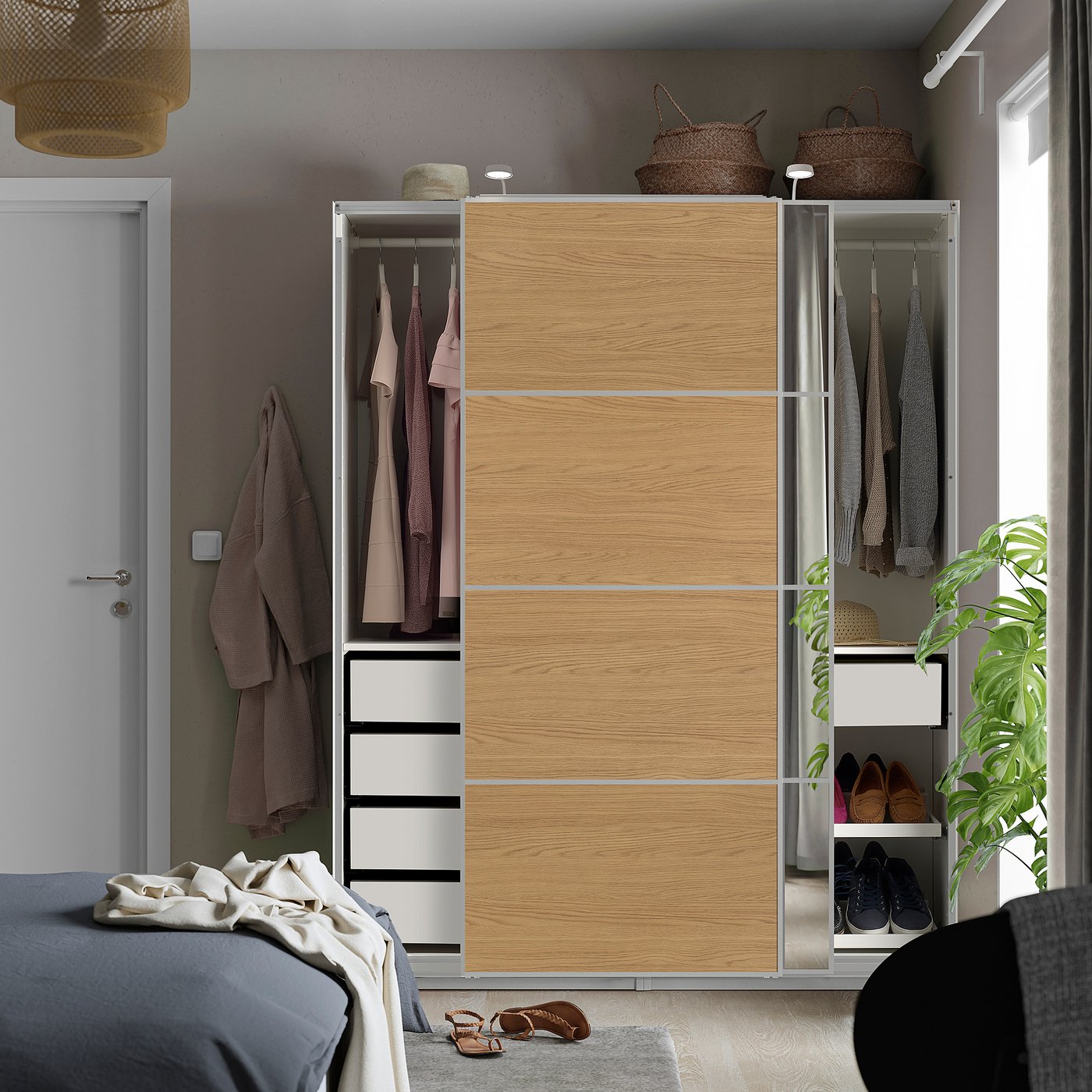 Modern bedroom with light wood PAX wardrobe, sliding doors, mirrored section, clothes & drawers, next to bed.
