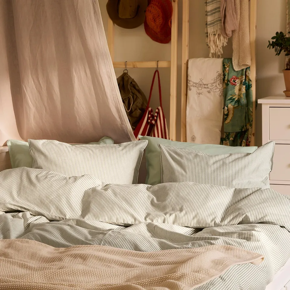 SOLFIBBLA duvet set on bed, light green/white stripes, 100% cotton, comfortable.