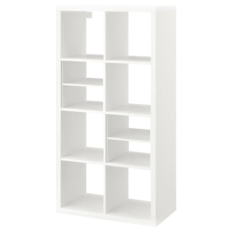 A white KALLAX shelving unit. Its a tall, rectangular, modular storage unit with multiple open cubes for customizable shelving.