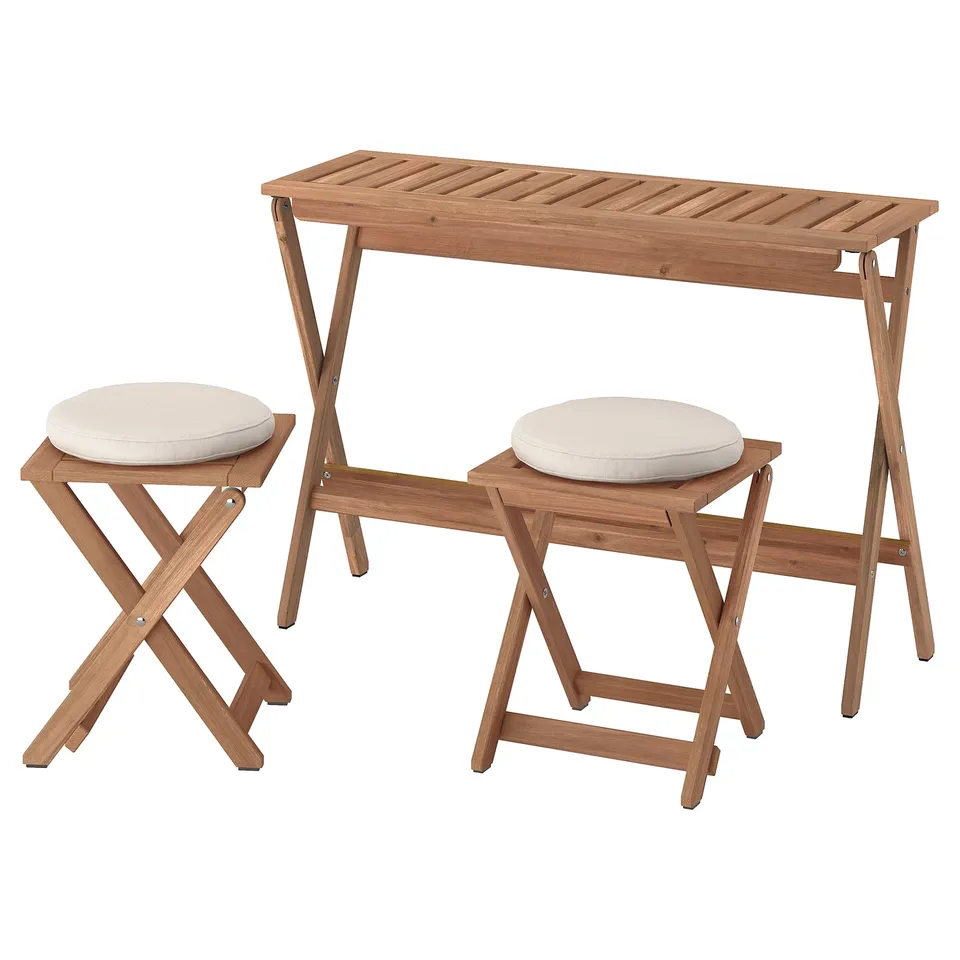 A NÄMMARÖ outdoor furniture set in brown. It includes a rectangular foldable table and two stools with white cushions.