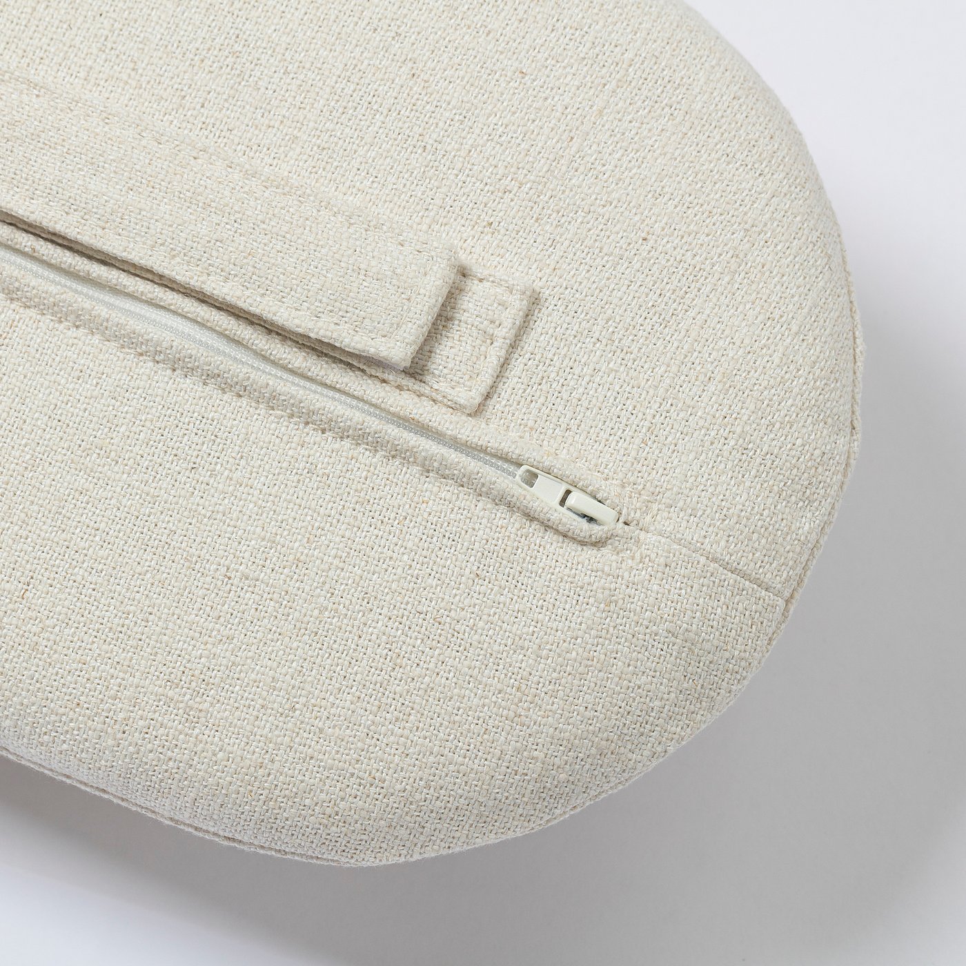 Close-up of natural woven armchair, zip detail, high-quality stitching, cream-colored.