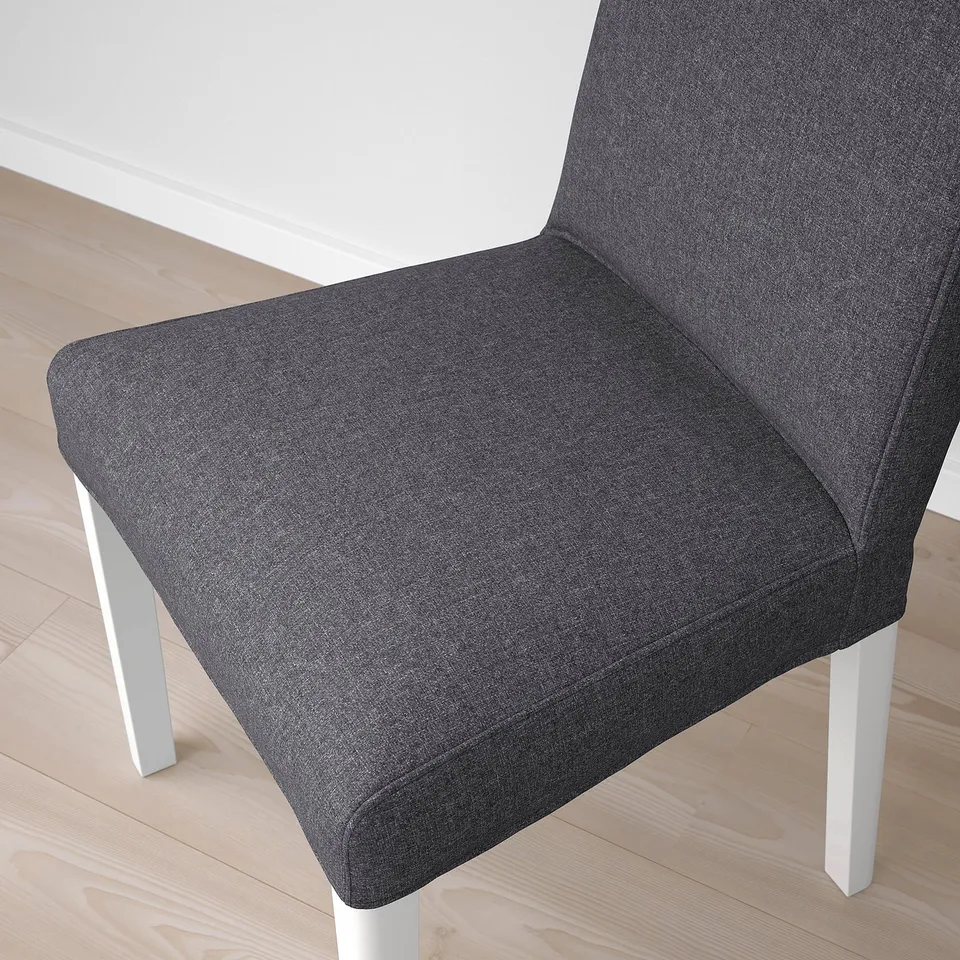 Modern upholstered chair with sleek grey fabric and white legs, designed for comfort and style.