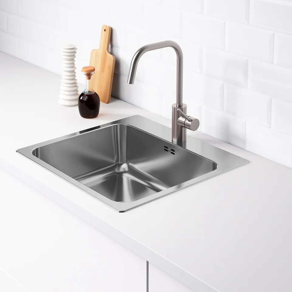 Stainless steel sink with modern tap in sleek kitchen setup.