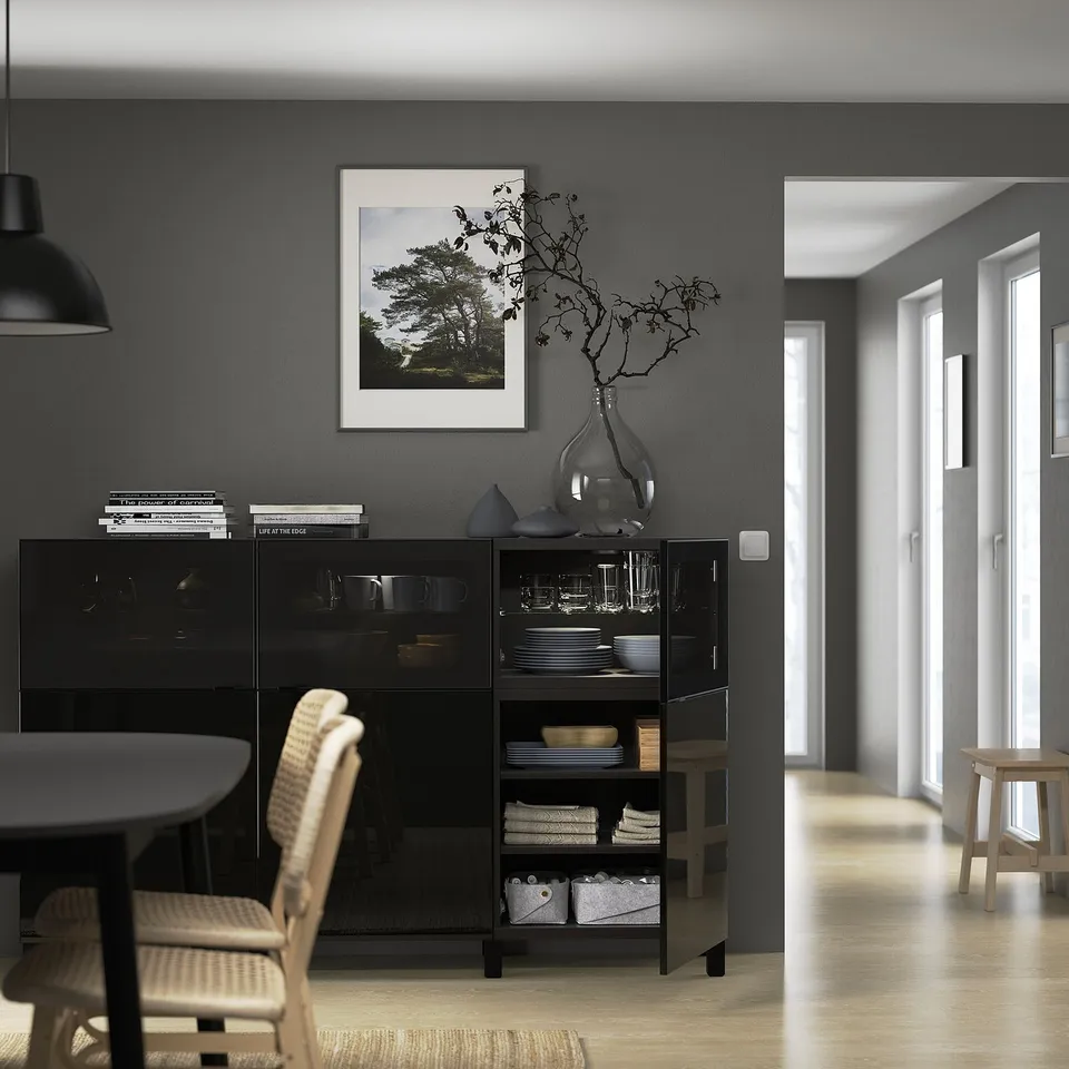 Modern dining room with BESTÅ sideboard, glass doors, & decor.