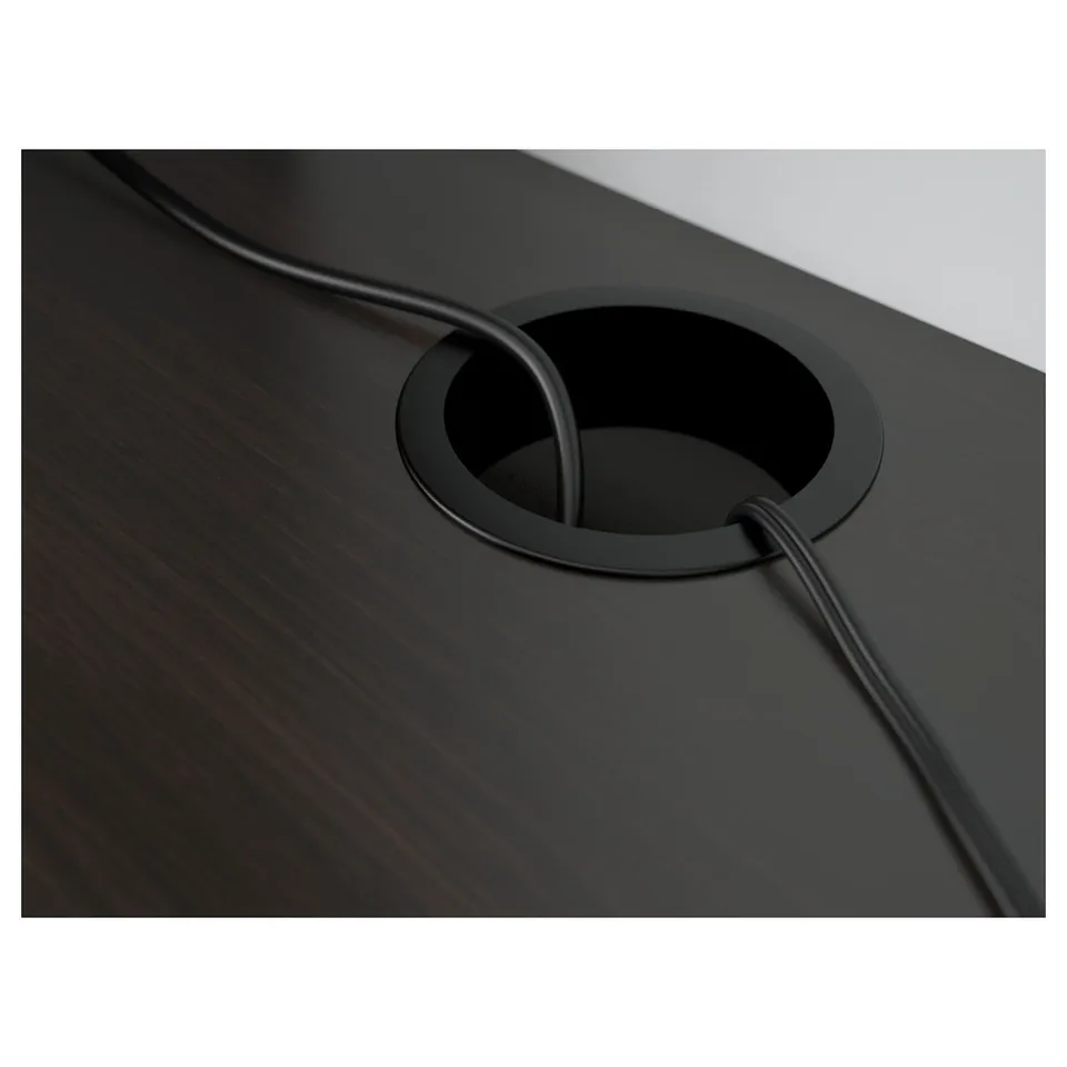 Dark wooden desk with a round cable outlet at the back, keeping cables organised and hidden.