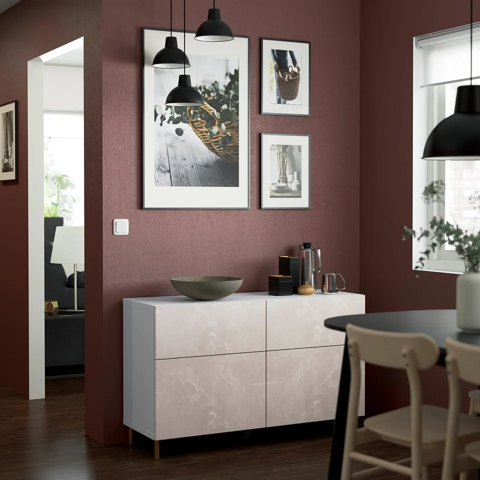 Modern living room with BESTÅ sideboard, marble, black accents, red wall, decor, lights.