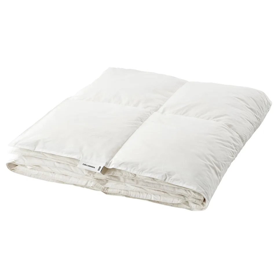 A white fjällräven FJÄLLARNIKA duvet. Its rectangular with stitched compartments, designed for warmth with a cotton cover and down filling.