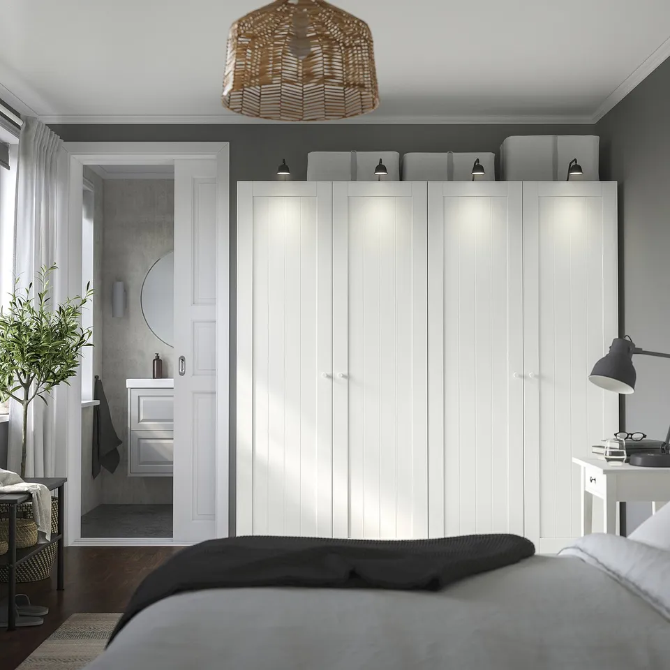 Modern minimalist bedroom with large grey PAX wardrobe, bed, and stylish decor.