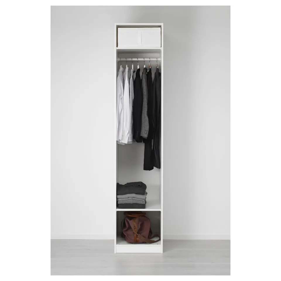 White wardrobe with hangers, folded clothes, and bag.