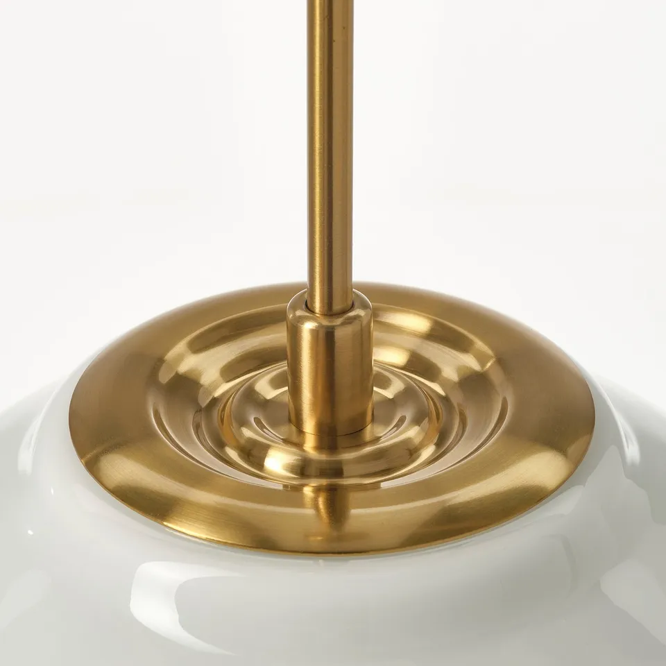Metal base supports glass shade, intricate design.