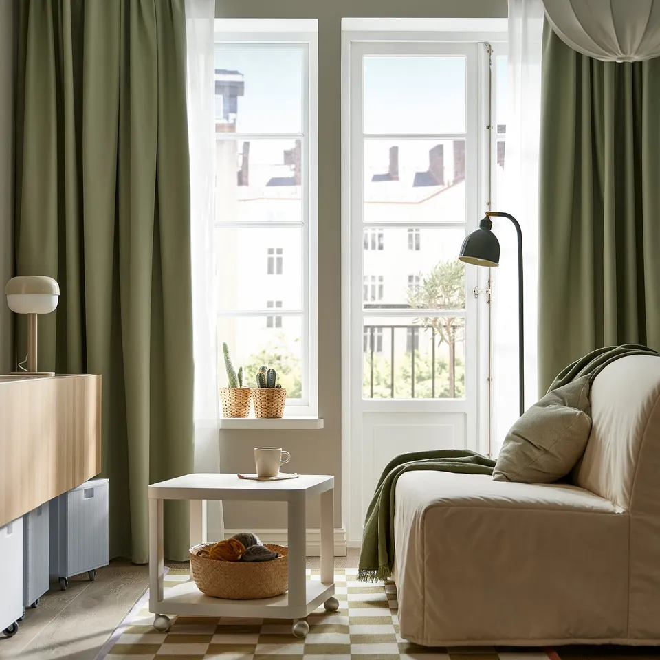 Green curtains, bed, tables, cactus