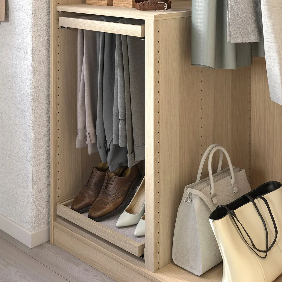 Wooden closet organiser with light-colored shelves, hanging clothes, brown shoes, and beige handbags.