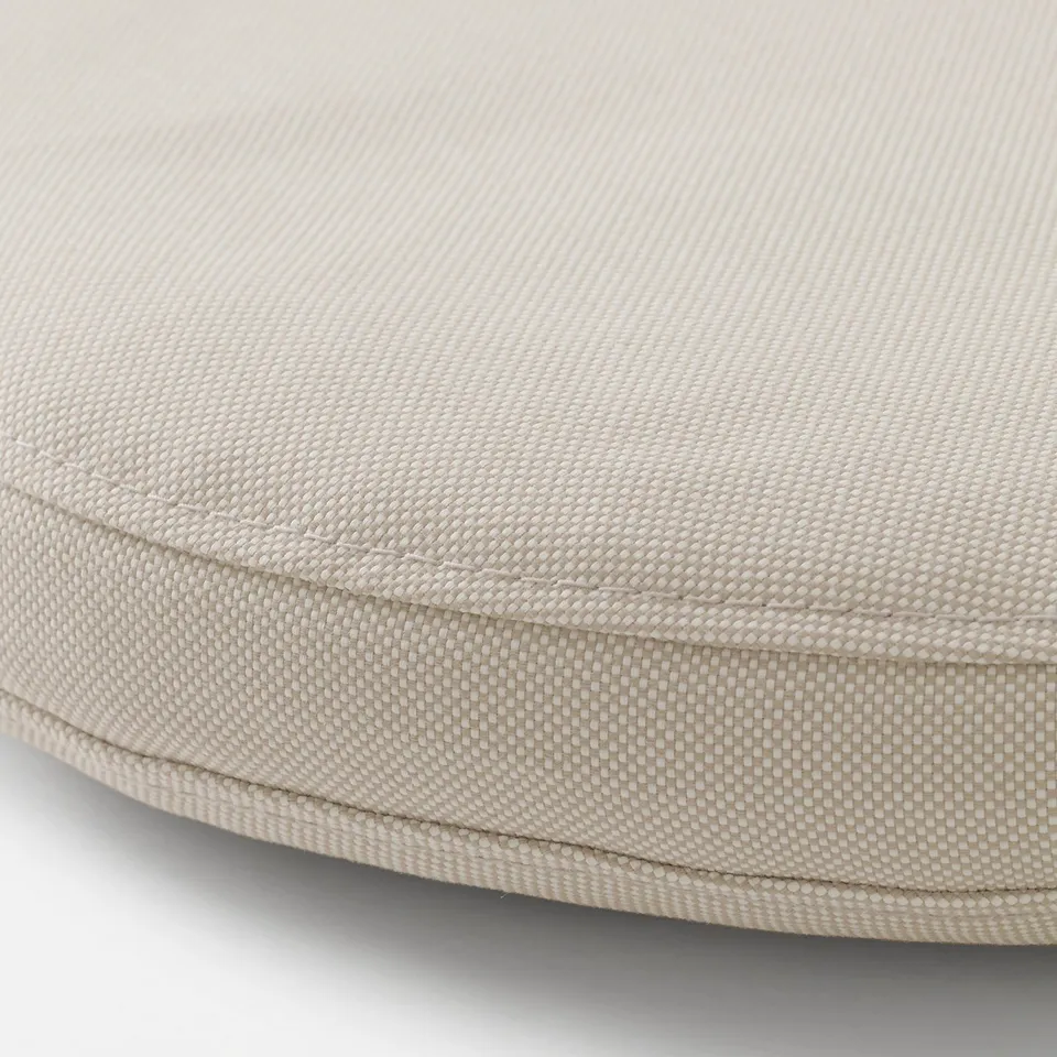 Circle cushion close-up, soft beige fabric, neat stitching, appears durable and comfortable.