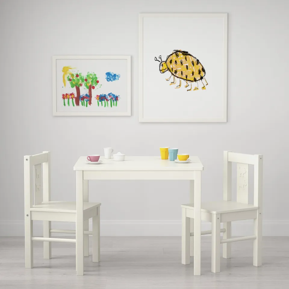 Kids table and chairs set with artwork. Perfect for play, drawing, or arts and crafts for ages 3-6.