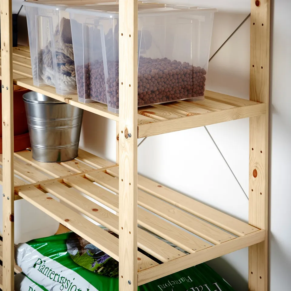 Shelf storage system with clear bins and buckets, holding various items.