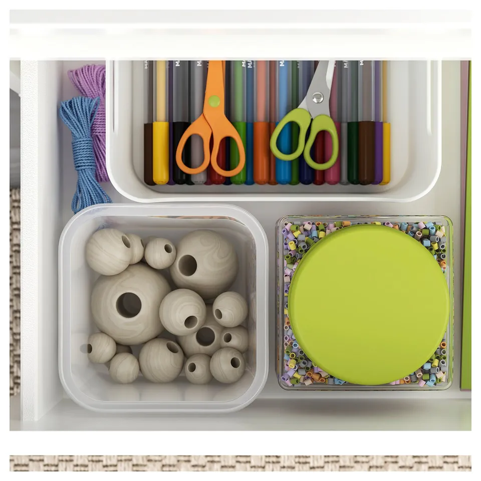 Organised craft drawer with colourful markers, scissors, wooden beads, and a round tray of beads.