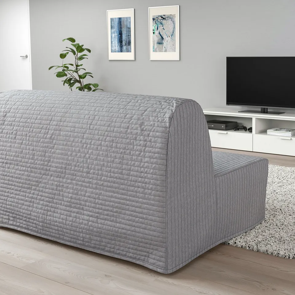Lycksele grey sofa-bed in living room with art prints, tv, and rug.