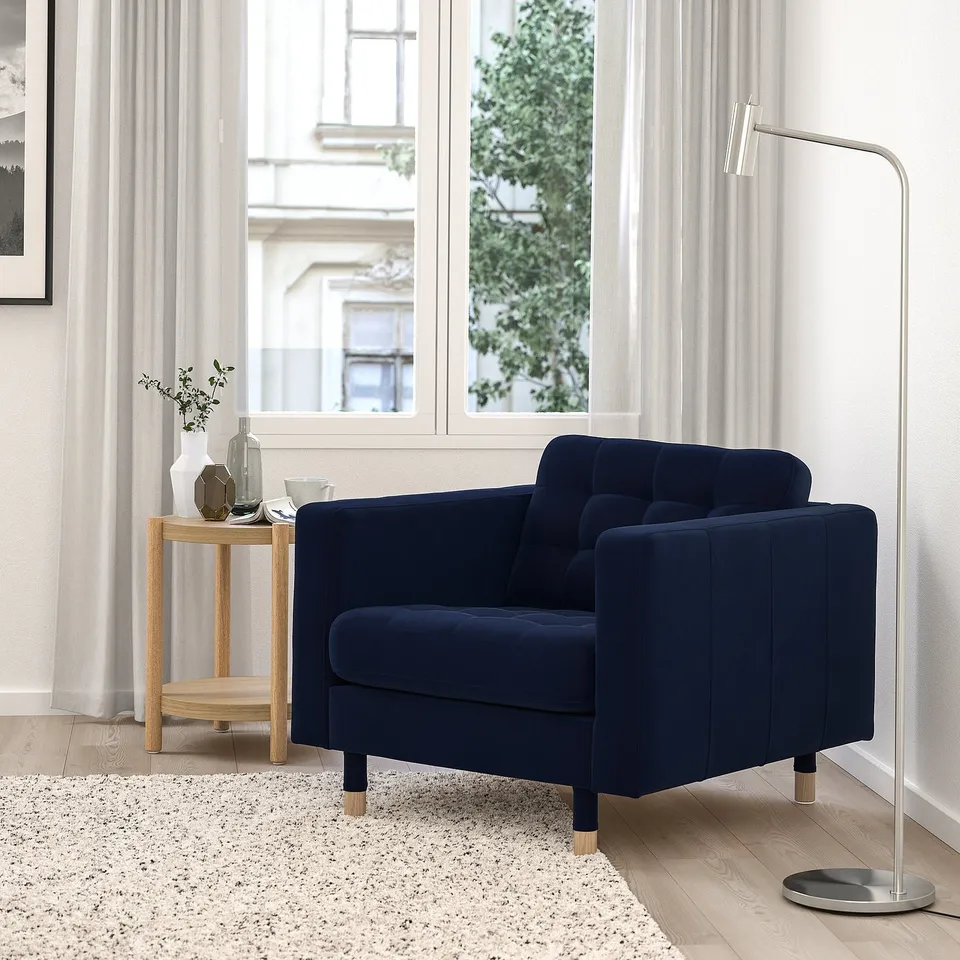 Modern living room with blue LANDSKRONA chair, lamp, side table, and natural light curtains.