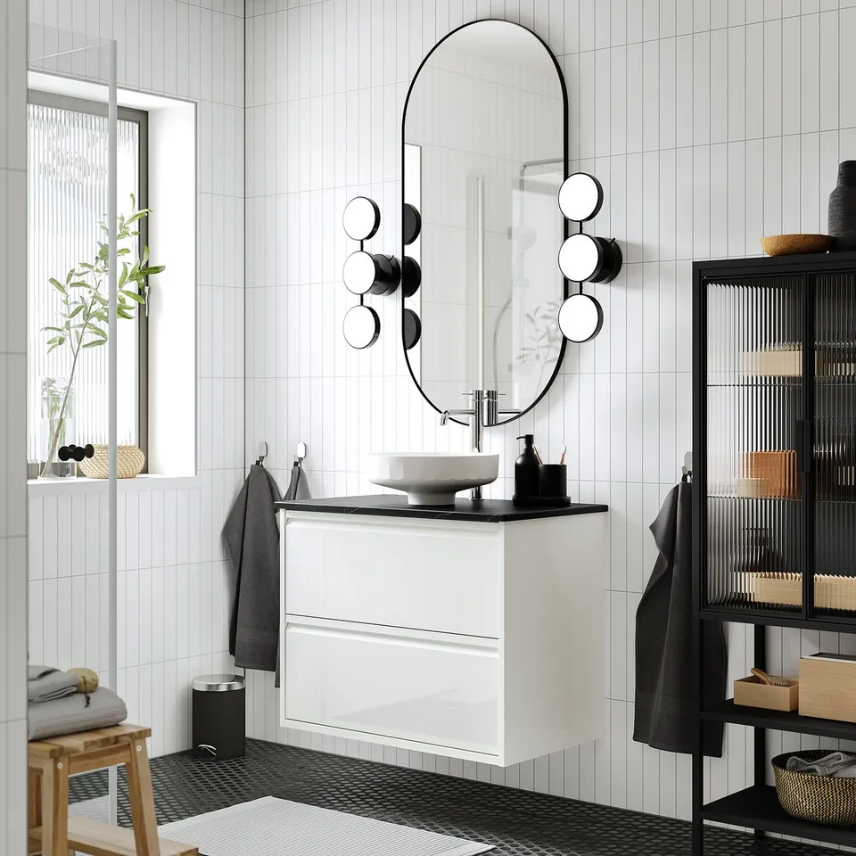 Modern bathroom: ÄNGSJÖN sink, dark decor, mirror, lights, hooks, stool, basket.