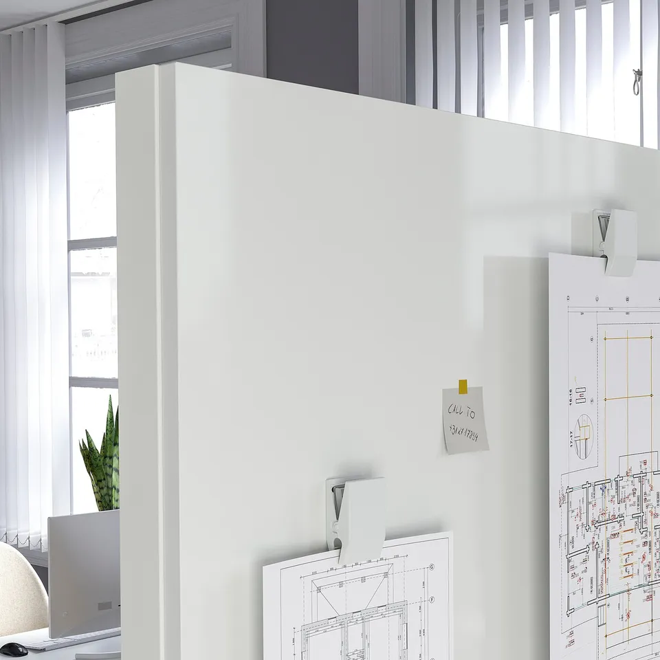 Whiteboard on castors with pinned papers near window in office.