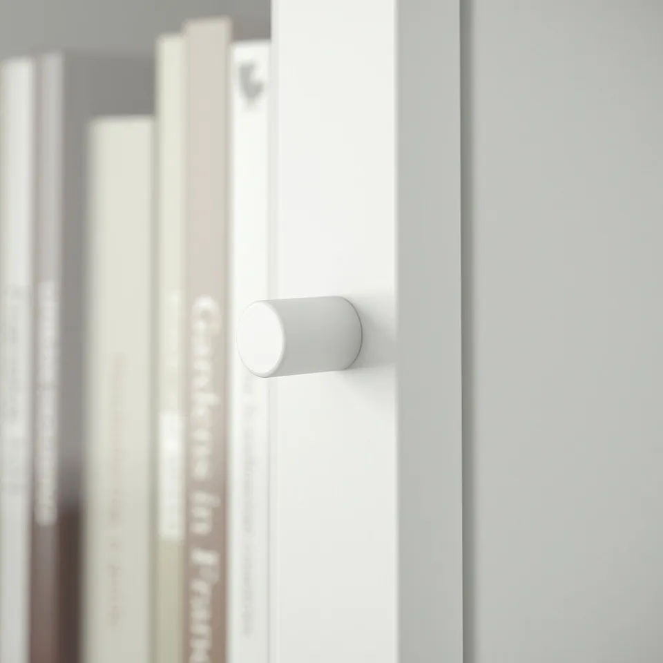 White BILLY bookcase with cylindrical handle, minimalist design.