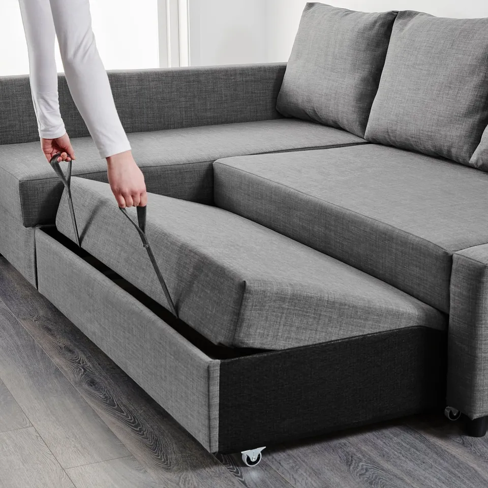 Person extends sofa beds hidden storage under seat. Grey fabric, modern design, practical and space-saving.