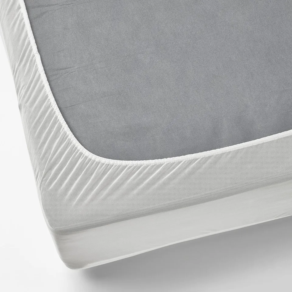 A thin, waterproof mattress protector in grey with white elastic edges, designed to keep mattresses clean and stain-free.