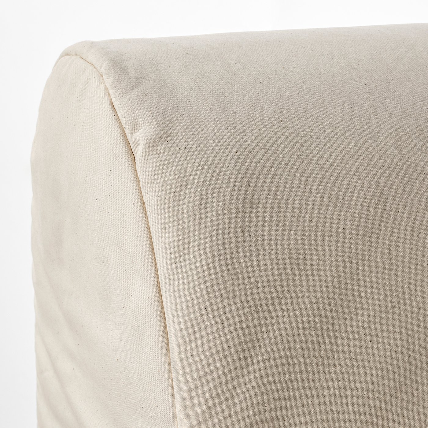 Close-up of a beige sofas plush, soft fabric showcasing its smooth texture and clean stitching, highlighting comfort and quality.