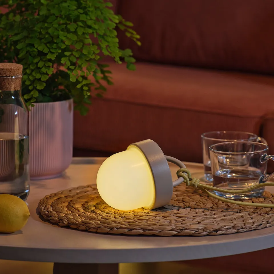 Solar light, lemon, cups on woven placemat.