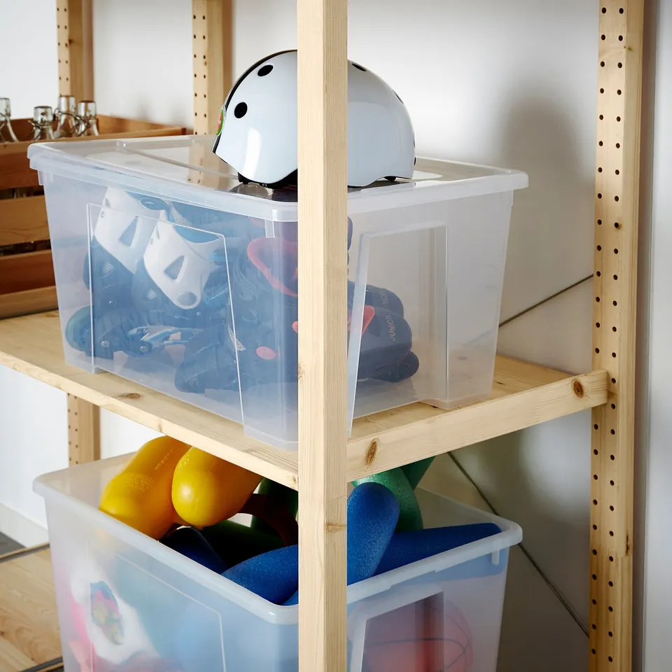 Shelves with clear plastic bins storing toys and sports gear.
