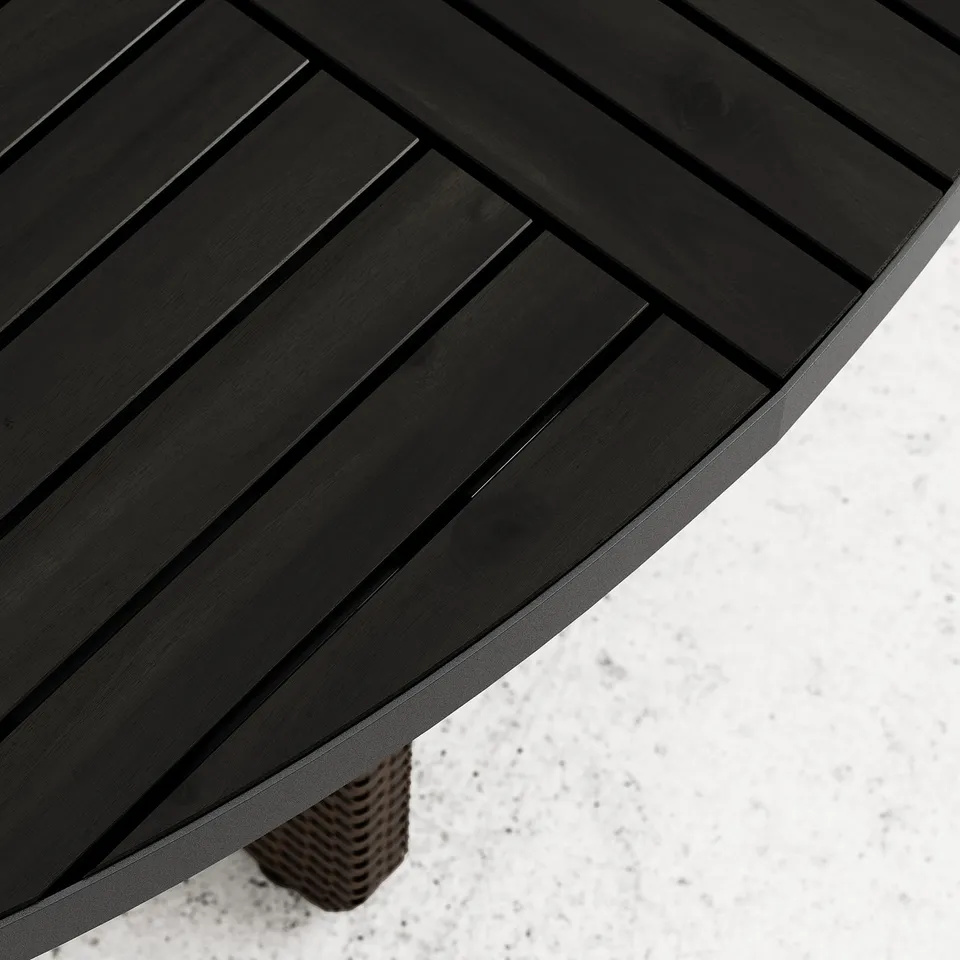 Dark wooden table with slatted design, showing smooth and polished surface, supported by a woven base.