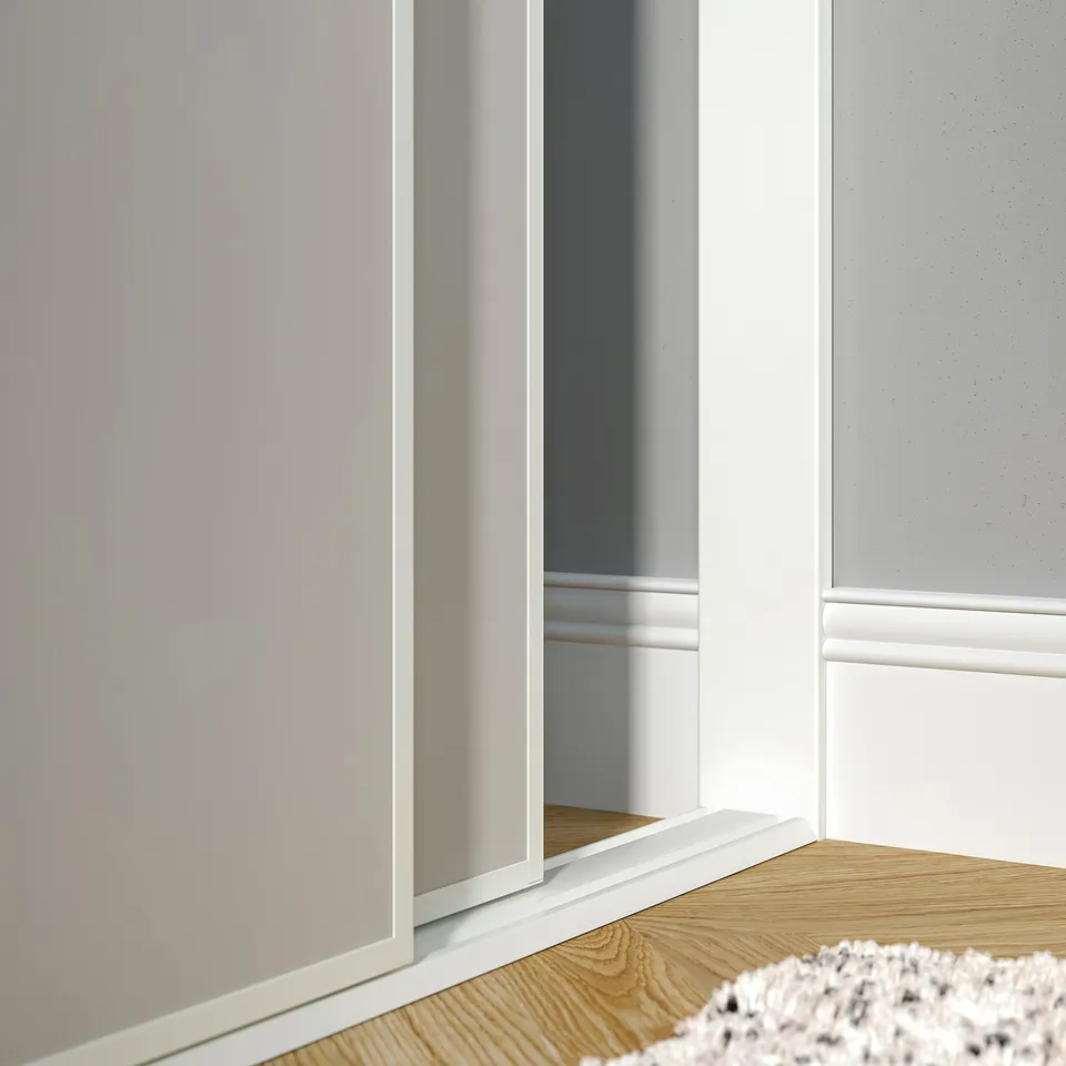 White door stop bridging wall gap, fixing skirting board.