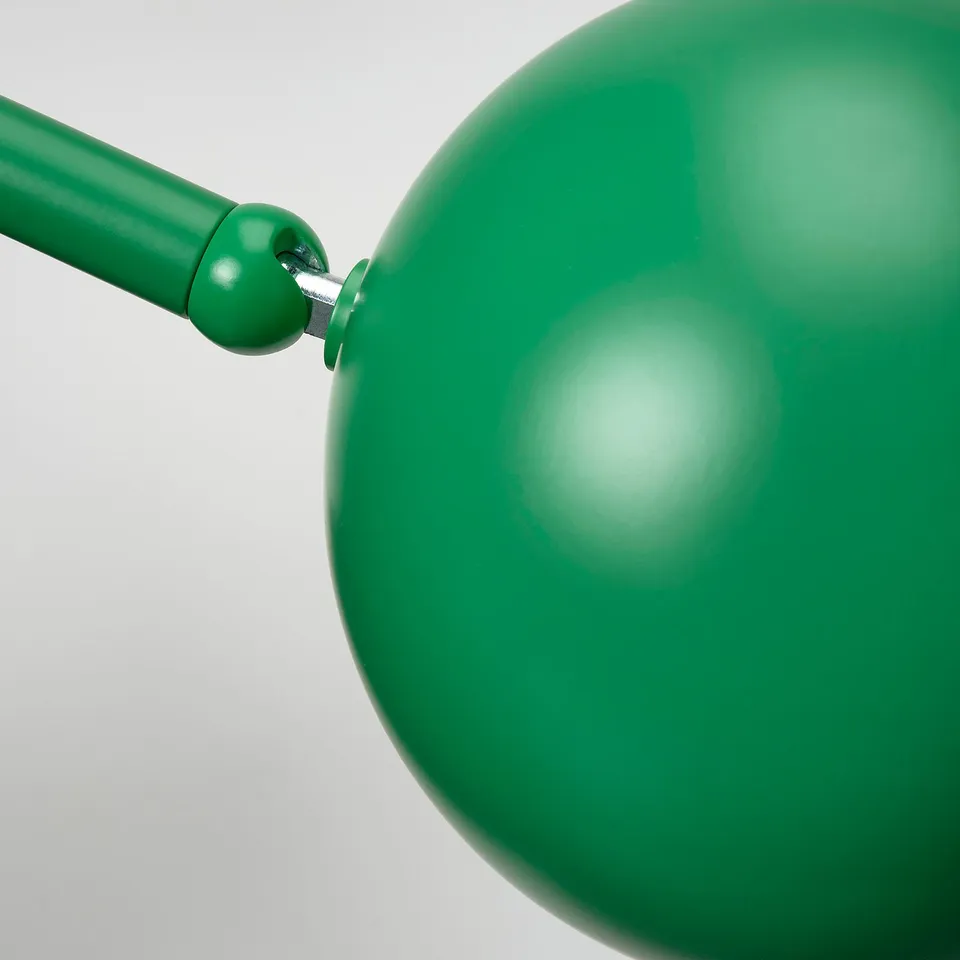 A modern, green lamp with a rounded shade attached by a sturdy joint, reflecting quality craftsmanship.