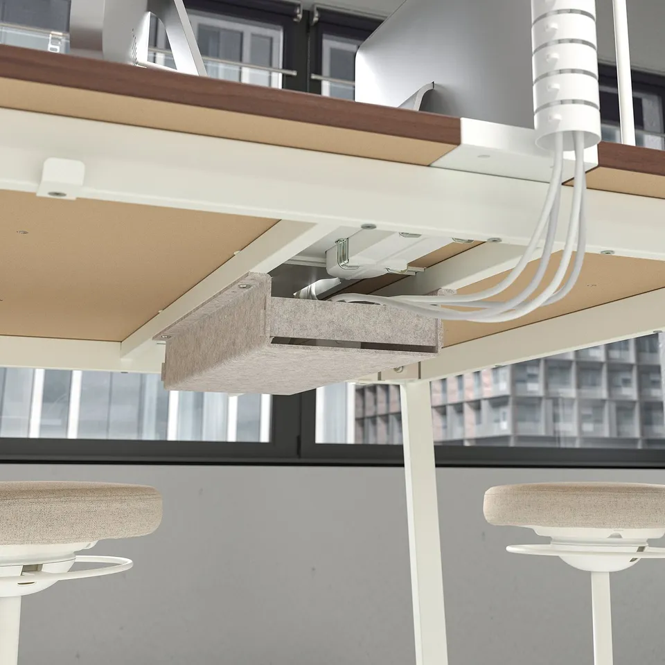 High conference table with built-in footrest and cable management for meetings.