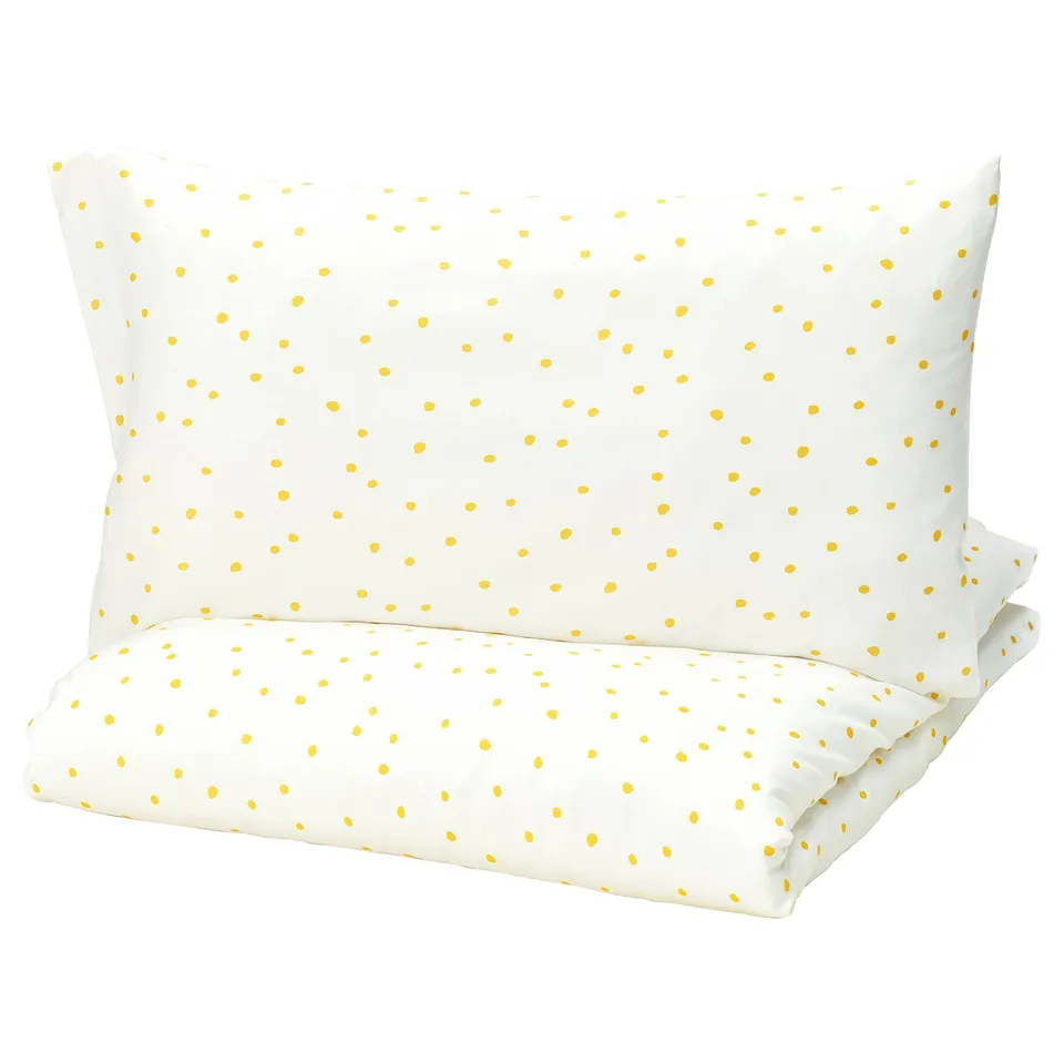 Barndrom pillow, yellow dots on white, rectangular shape.