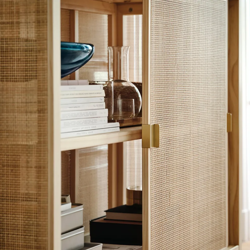 Rattan cabinet with sliding doors. Brass handles; adjustable feet for stability on uneven floors.