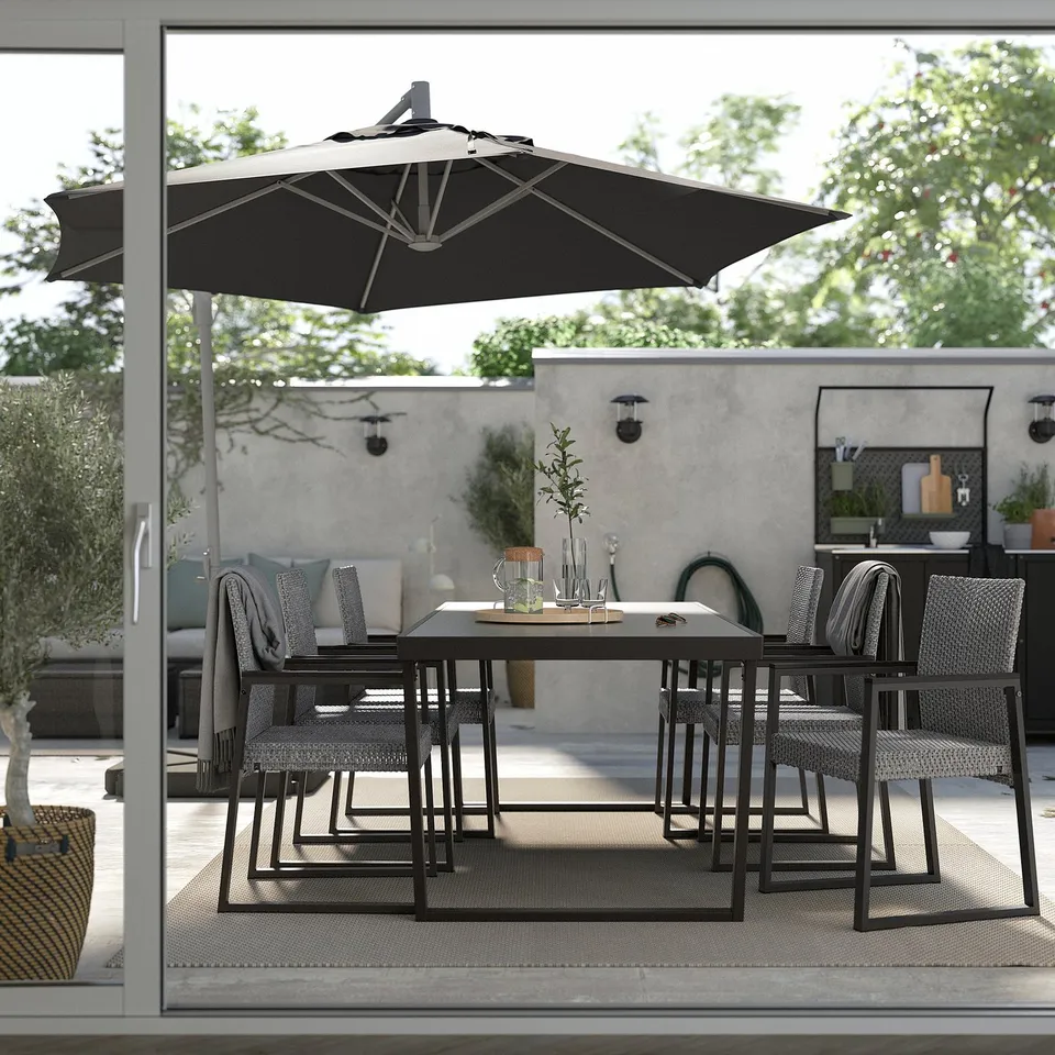 Modern patio set with black umbrella, table, and chairs. Woven textures, clean lines, perfect for outdoor dining.