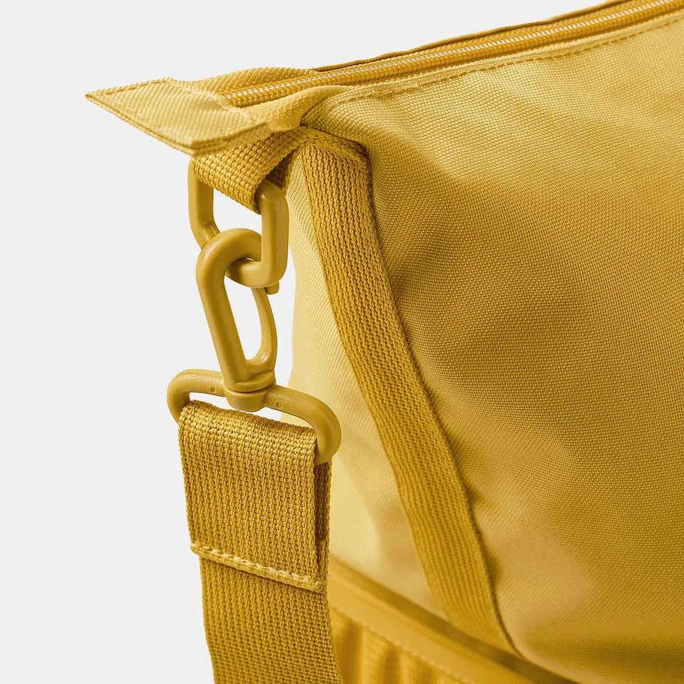 Close-up of tan KLOTPIL bags sturdy tan carabiner and robust fabric, highlighting its quality construction.