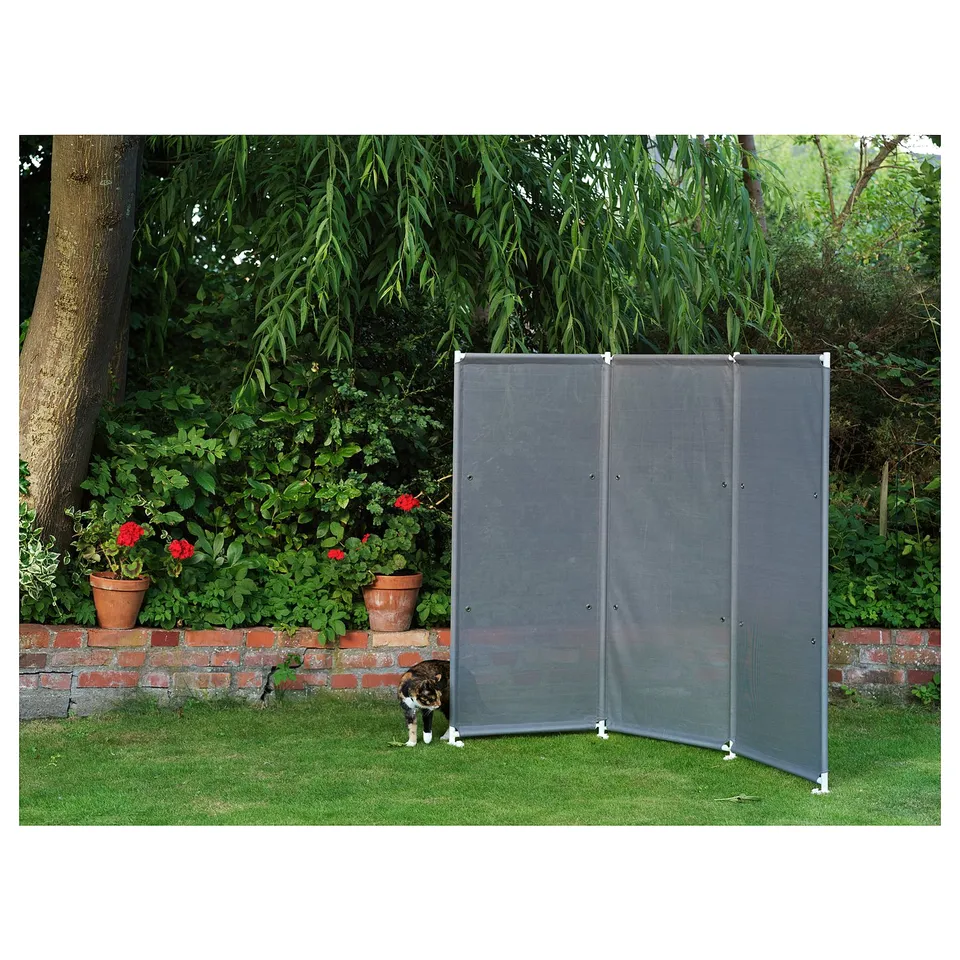 Black outdoor privacy screen consisting of three panels in a garden, providing a sense of a separate room.