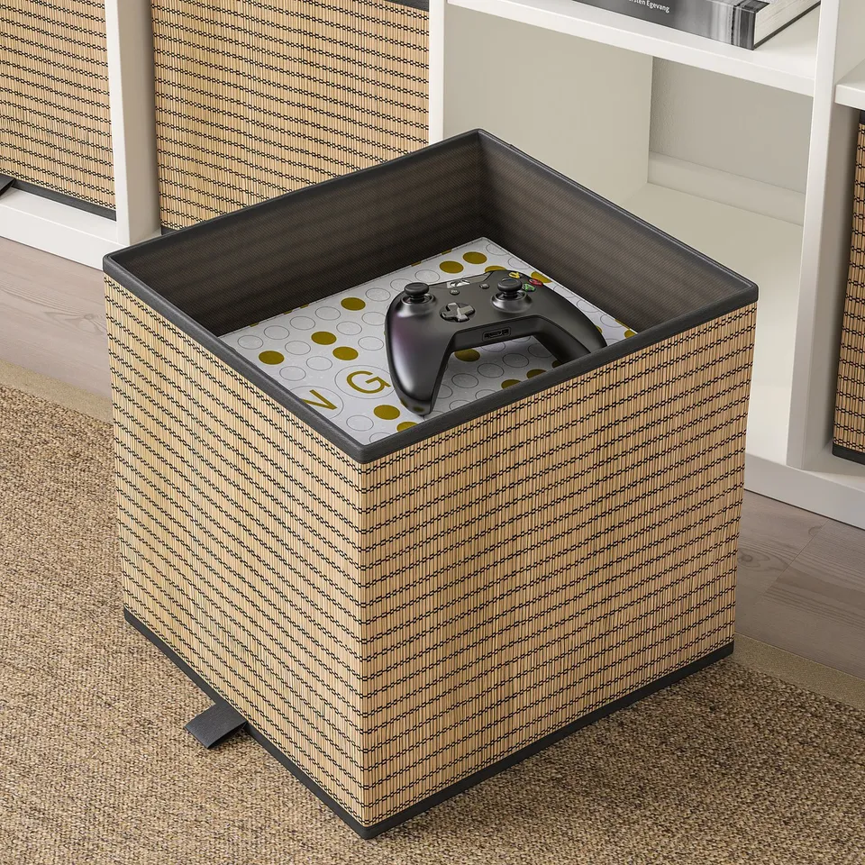 Gaming controller in beige storage box on carpeted floor.