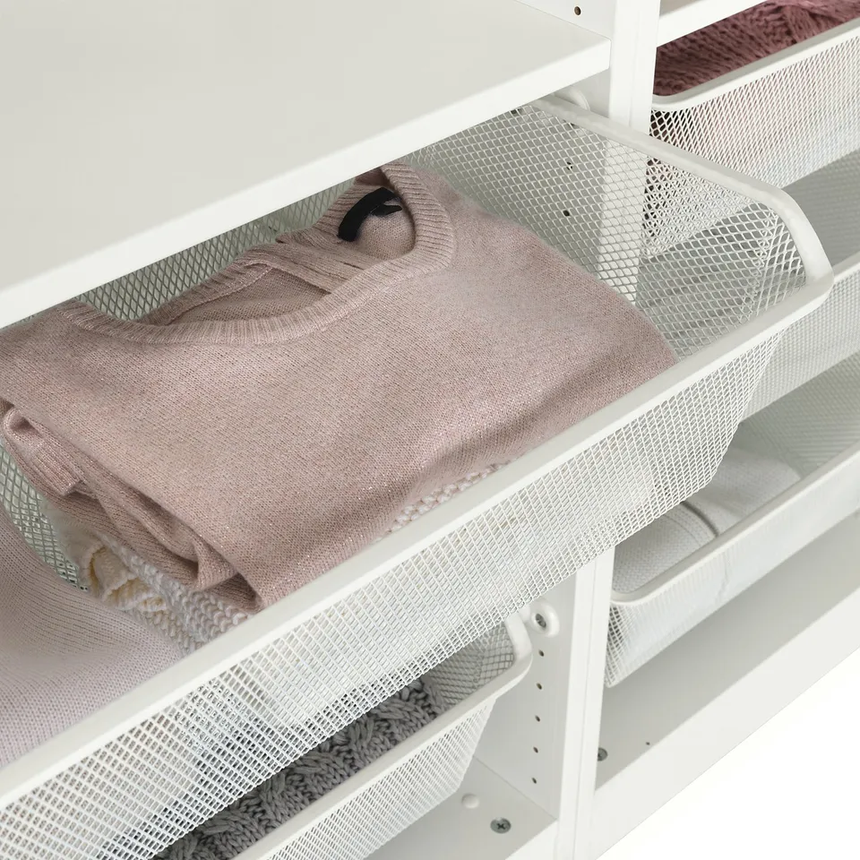 Mesh basket in white wardrobe, showing folded light-colored clothes, allowing air circulation and visibility.