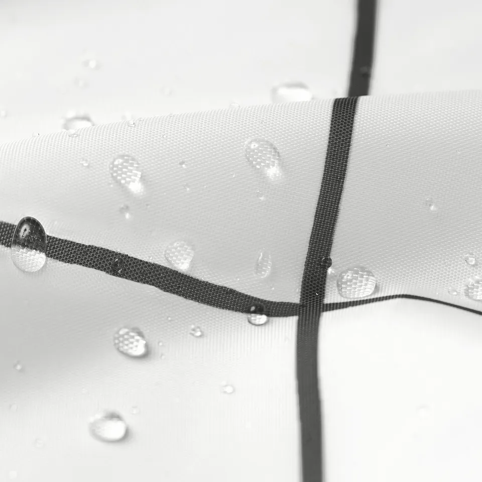 Water droplets bead on shower curtain surface, demonstrating repellent quality.