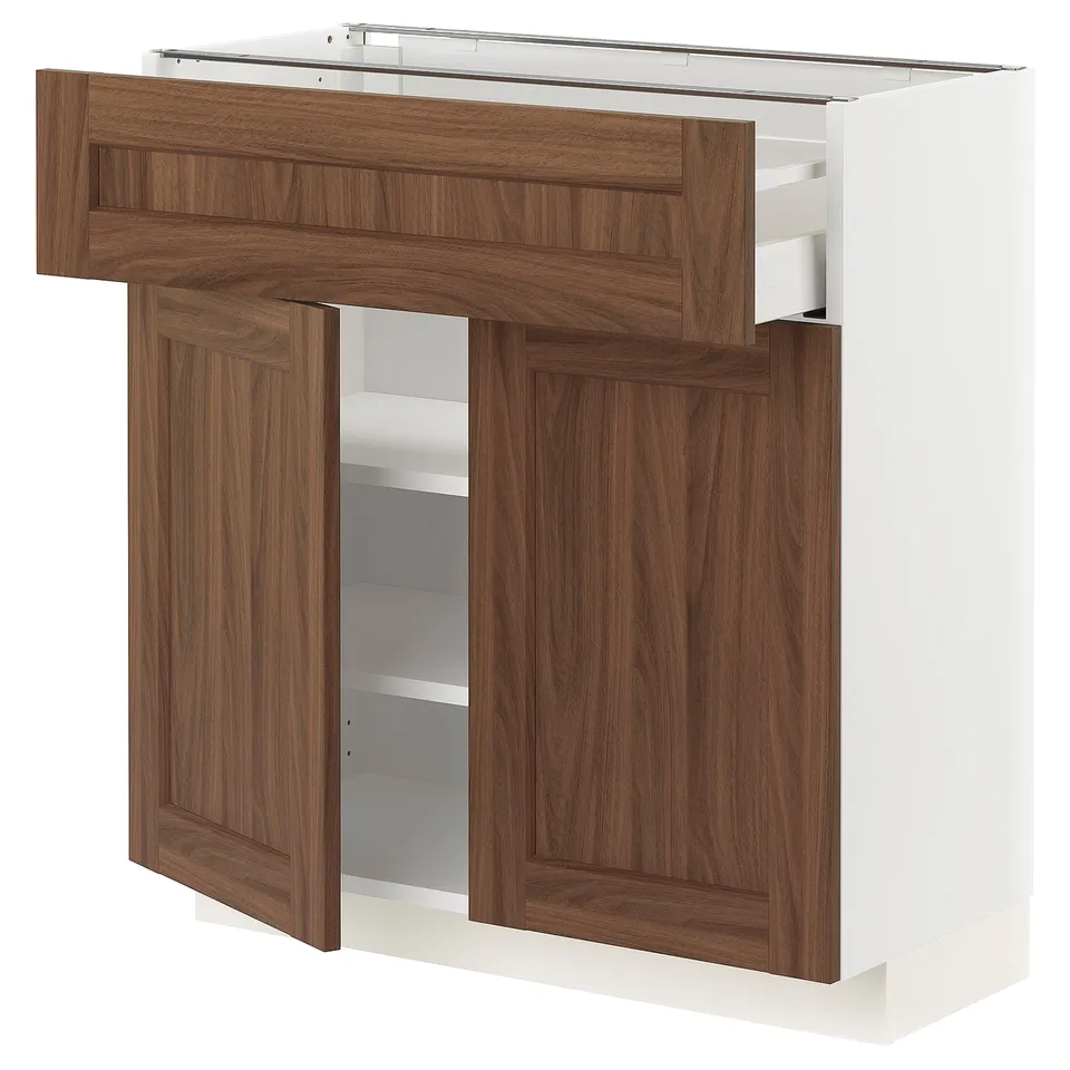 A METOD kitchen unit with walnut wood-effect doors and a white frame. It includes drawers and shelves for storage.